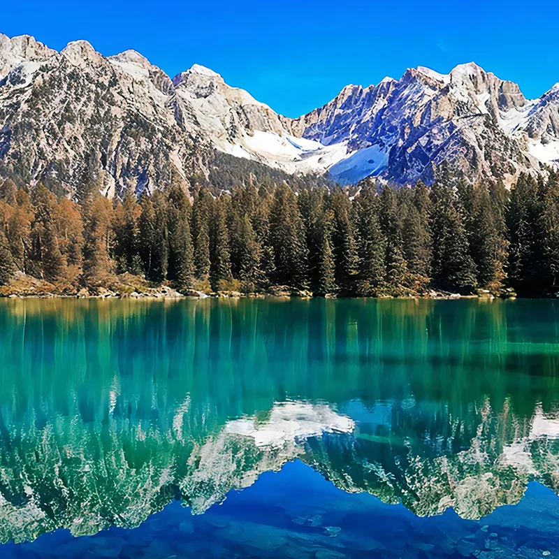 Quadro Montagne Lago Mozzafiato Con Acque Riflettenti Circondato Da Maestose Vette Montuose