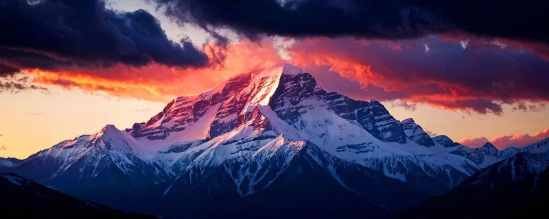 Wall Mural Mountains Majestic Snow-Capped Mountain At Sunset With Dramatic Sky